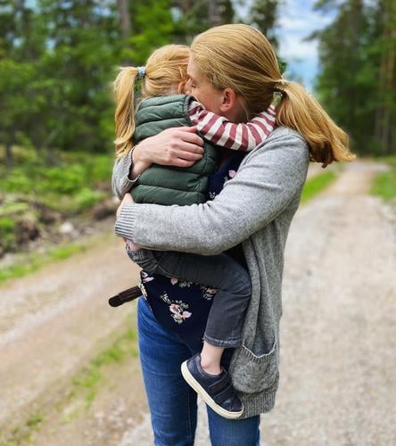 Eine Mutter kuschelt mit ihrer Tochter auf dem Arm innig vertraut Vertrauen Geborgenheit geborgen Mutter mit Kind Mutterliebe Muttergefühl Mutter und Tochter