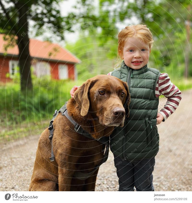 Kleines Mädchen mit braunem Labrador Labrador Retriever Hund Kind rote Haare Schwedenhaus schwedenrot draußen Hundeliebe Hund und Mensch Hund und Herrchen
