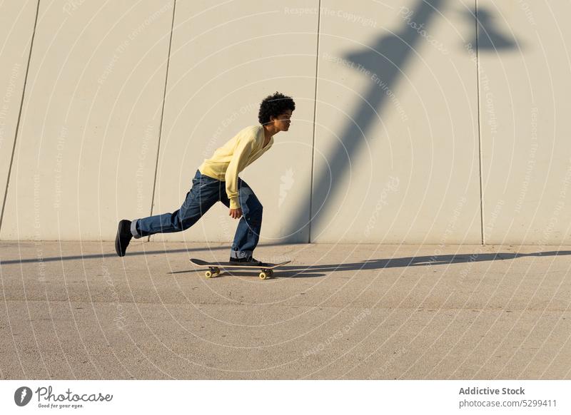 Energetischer Mann beim Skateboarden auf der Straße Skater Wand Aktivität Energie extrem urban männlich jung Stunt Sport dynamisch aktiv ausführen Fähigkeit