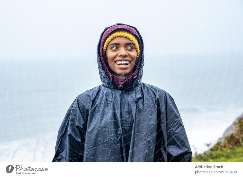 Ernste Frau im Regenmantel auf dem Meer während eines Ausflugs Wanderer Reisender Urlaub Porträt ernst Tourist MEER Tourismus Natur wolkenlos reisen jung Küste
