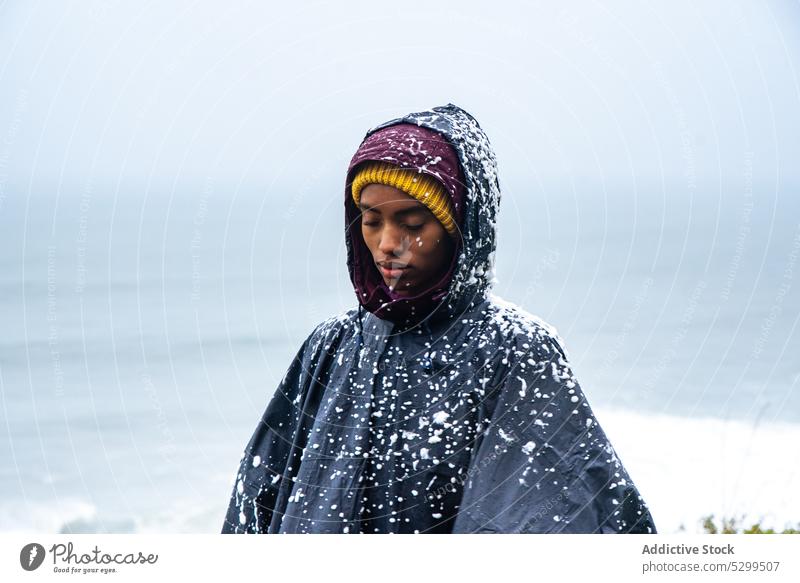 Touristin im Regenmantel mit Schnee bedeckt Reisender Kapuzenpulli Urlaub Deckung erkunden bewundern Natur Himmel stürmisch idyllisch Wetter wolkenlos Fernweh
