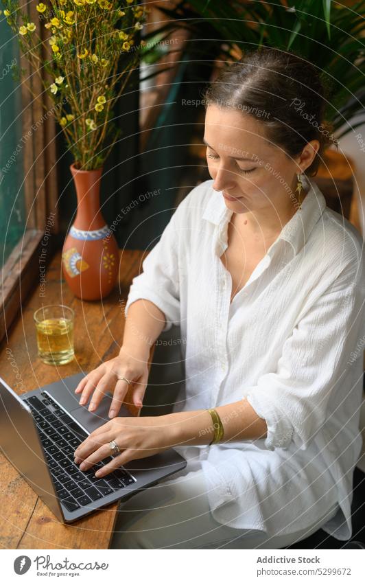 Konzentrierte Frau mit Laptop in einem Café freiberuflich Tippen abgelegen Arbeit benutzend Browsen Gerät Vietnam Apparatur Projekt Netbook online Tisch
