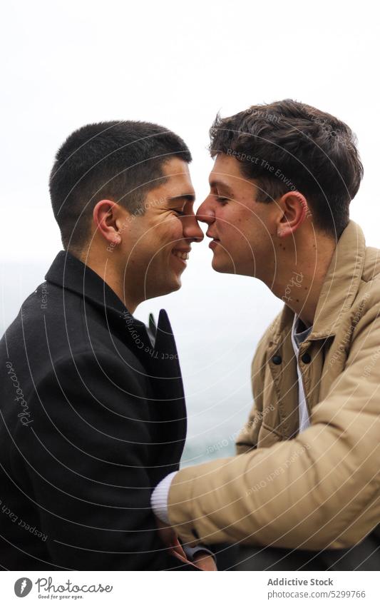 Glückliches schwules Paar, das sich auf der Straße küsst Kuss Nase Liebe Homosexualität Freund Partnerschaft lgbt gleichgeschlechtlich Lächeln jung Zusammensein