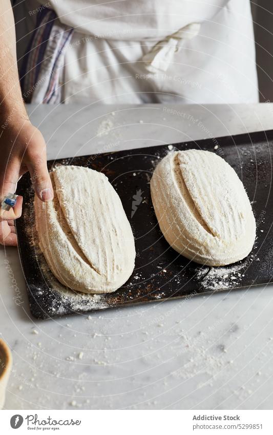 Crop-Bäcker ritzt Sauerteigbrot Teigwaren geschnitten Punktzahl Handwerk Koch Gebäck Tisch vorbereiten Küche Bäckerei Prozess roh frisch Lebensmittel ungekocht