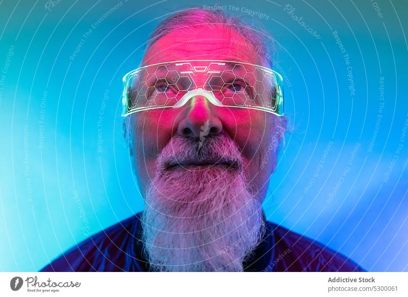 Selbstbewusster älterer Mann mit Brille neonfarbig Hipster Vollbart Porträt ernst Stil selbstbewusst leuchten männlich Senior Licht besinnlich reif hell modern