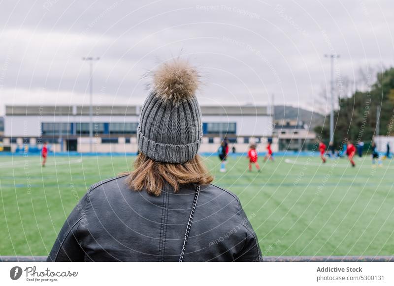 Unbekannte Frau in warmer Kleidung beim Fußballspiel Feld Streichholz Stadion Sport warme Kleidung zuschauen Spiel Hut tagsüber Training Konkurrenz Zuschauerin