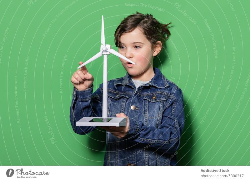 Lächelndes Kind mit Windrad-Mockup Mädchen Glück Kraft Attrappe Windmühle Energie eolicisch Erzeuger Fokus lässig heiter regenerativ alternativ Energetik Freude