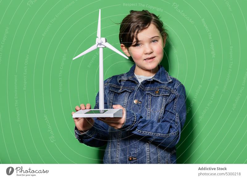 Lächelndes Kind mit Windrad-Mockup Mädchen Glück Kraft Attrappe Windmühle Energie eolicisch Erzeuger Fokus lässig heiter Freude Kindheit positiv aufgeregt