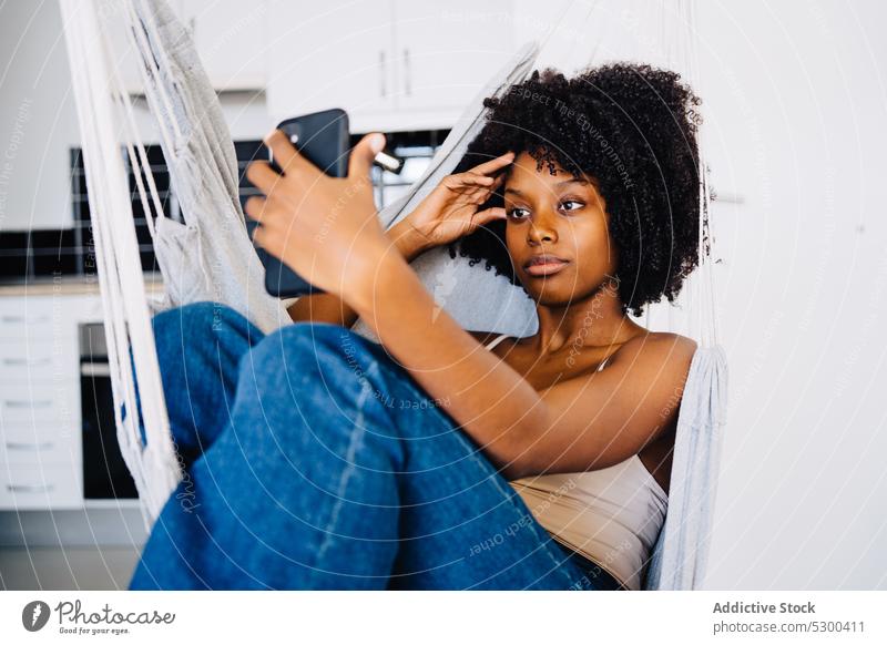 Schwarze Frau macht Selfie auf Hängematte Smartphone benutzend Afroamerikaner schwarz jung Glück positiv lässig ruhen krause Haare Telefon Mobile Selbstportrait