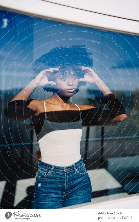 Trendige schwarze Frau schaut zum Fenster Windstille ernst Haare berühren Afro-Look besinnlich Reflexion & Spiegelung Frisur heimwärts afroamerikanische Frau
