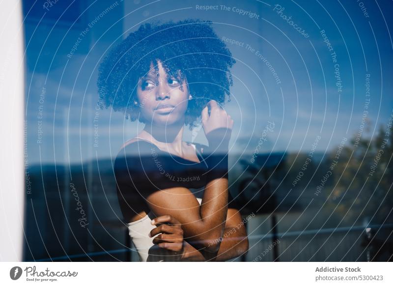 Trendige schwarze Frau schaut in der Nähe des Fensters weg Windstille ernst Afro-Look besinnlich Reflexion & Spiegelung Frisur heimwärts afroamerikanische Frau