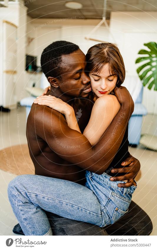Liebendes multiethnisches Paar, das sich zu Hause umarmt romantisch Umarmung Umarmen vielfältig Bonden Zuneigung sinnlich sich[Akk] entspannen heimwärts