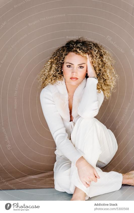Selbstbewusste Frau in weißer Kleidung sitzt auf dem Boden Model Studioaufnahme Make-up traumhaft charismatisch selbstbewusst selbstsicher Vorschein