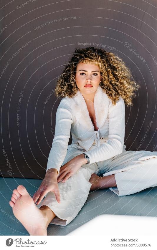 Selbstbewusste Frau in weißer Kleidung sitzt auf dem Boden Model Studioaufnahme Make-up traumhaft charismatisch selbstbewusst selbstsicher Vorschein