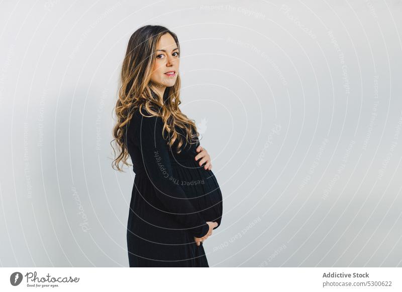 Ruhige schwangere Frau, die ihren Babybauch berührt Liebe Streicheln Bauch anfassen warten führen pränatal erwarten jung Unterleib feminin sinnlich Pflege