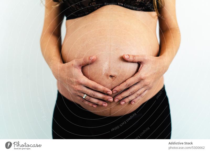 Crop schwangere Frau berührt Bauch Studioaufnahme Liebe Streicheln Bauch anfassen Babybauch Mutterschaft pränatal Schwangerschaft Unterwäsche jung Eltern