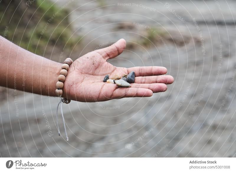 Person zeigt kleine Steine in einer Schlucht Reisender Handfläche Felsen wüst tatacoa Kolumbien Tourismus erkunden entdecken zeigen manifestieren Handvoll