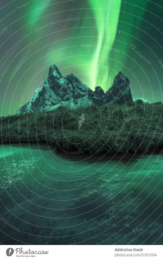 Aussicht auf verschneite Berge und einen See unter einem Himmel mit Polarlicht Nordlicht Berge u. Gebirge nördlich polar Licht Nacht Island Krossanesfjall