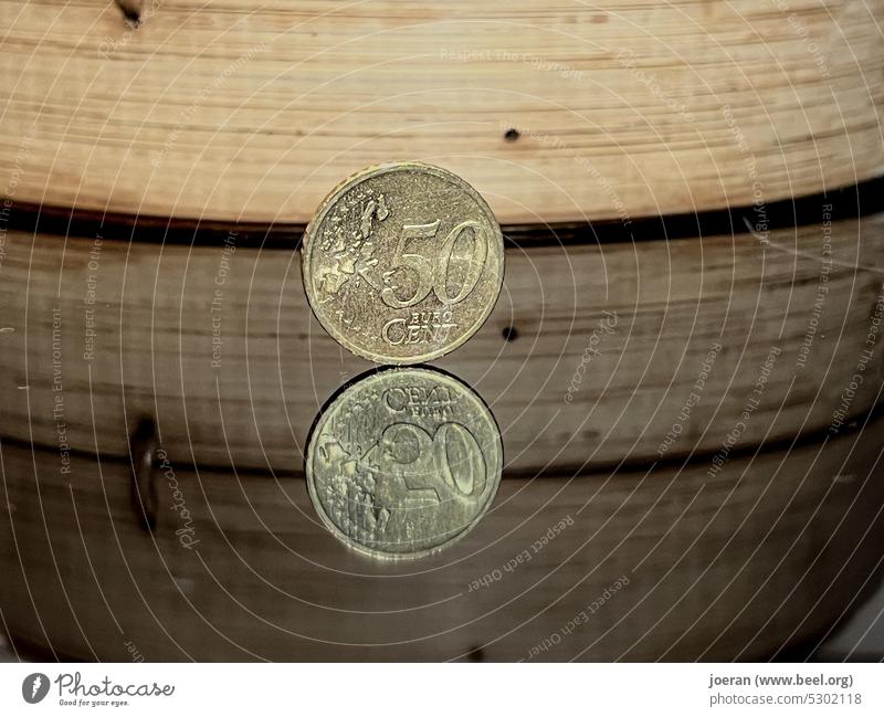 50 Cent Stück auf Spiegelfläche mit Bambuskorb im Hintergrund 50 cent Geld money 50 Cents Euro centstücke Eurocent Münzen Bargeld bezahlen Geldmünzen Kleingeld
