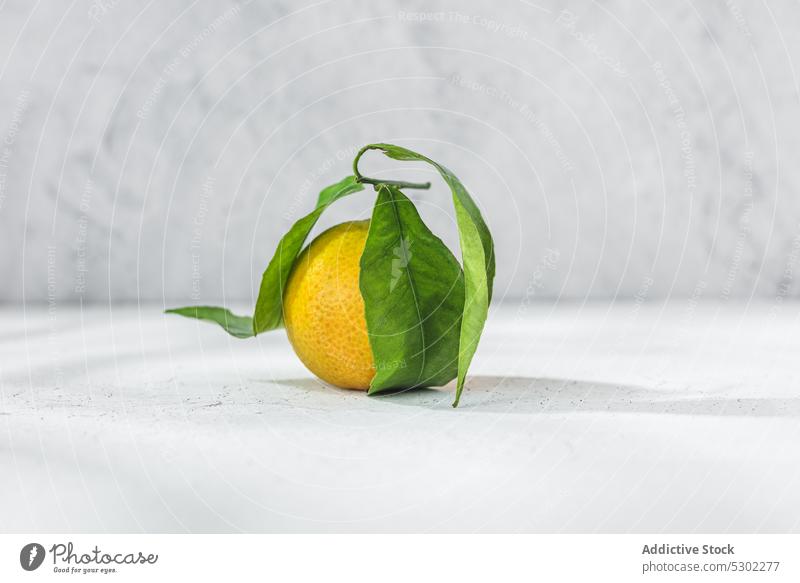 Orangefarbene Mandarine auf weißem Tisch orange Zitrusfrüchte pflanzlich Vorbau Blatt Blätter Frucht Mahlzeit Lebensmittel organisch Gesundheit roh frisch reif