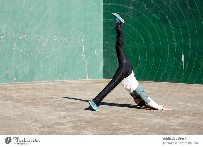 Energetische Frau, die Yoga praktiziert Straße Asana Gleichgewicht beweglich Beton Dehnung üben Pose verwittert Sportbekleidung Wellness Zen Energie Harmonie