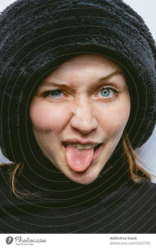 Positive Frau mit Hut zeigt Zunge Porträt Zunge zeigen expressiv lustig Grimasse Gesicht machen Glück ausspannen jung positiv Freude heiter spielerisch