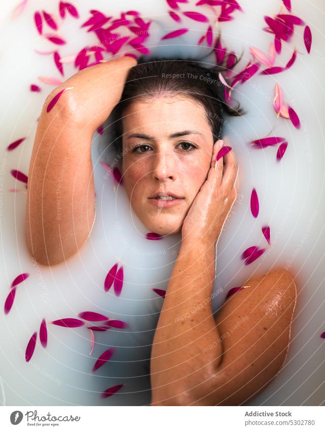 Ruhige Frau nimmt ein Bad mit rosa Blütenblättern und Milch melken Blume Blütenblatt Badewanne friedlich Hygiene Spa Kübel Hautpflege sinnlich Wellness ruhen