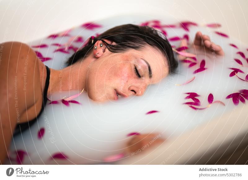 Ruhige Frau nimmt ein Bad mit rosa Blütenblättern und Milch melken Blume Blütenblatt Badewanne friedlich Hygiene Spa Kübel Hautpflege sinnlich Wellness ruhen