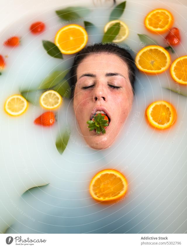 Badende Frau mit Erdbeere im Mund Zitrusfrüchte orange Scheibe melken essen Erdbeeren nasses Haar Spa Gesundheit verjüngen Verfahren Körperpflege Frucht Wasser