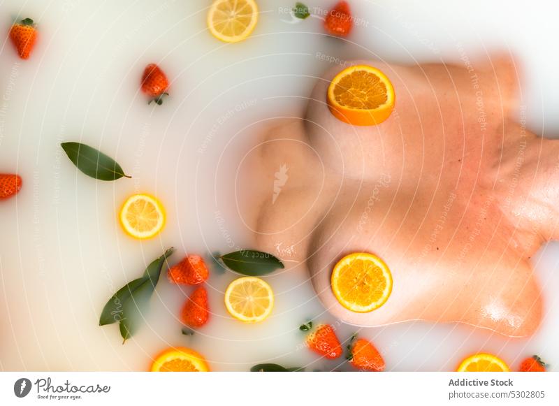 Anonyme Frau, die ihre Brustwarzen mit Orangenscheiben bedeckt Deckbrust Zitrusfrüchte Frucht orange Scheibe sich[Akk] entspannen melken Bad boob Hydrat