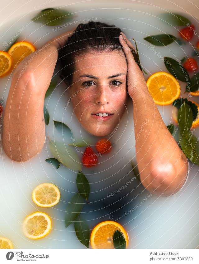 Badende Frau mit Erdbeere im Mund Zitrusfrüchte orange Scheibe melken essen Erdbeeren nasses Haar Spa Gesundheit verjüngen Verfahren Körperpflege Frucht Wasser