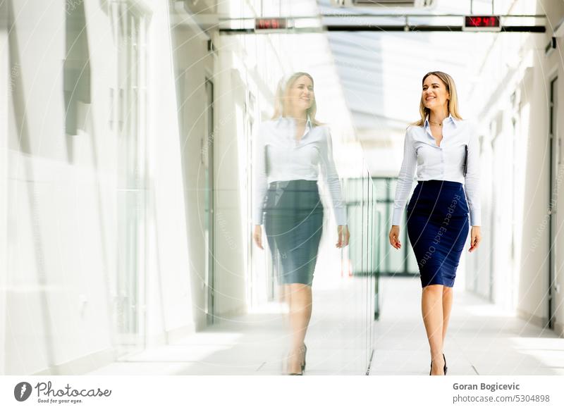 Junge Frau geht mit digitalem Tablet im Büroflur spazieren Erwachsener allein attraktiv schön Schönheit hell brünett Business Geschäftsperson Geschäftsleute