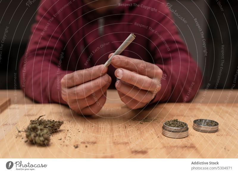 Anonymer Mann bereitet einen Joint zum Rauchen vor Cannabis Marihuana Unkraut Gelenk Medikament rollen stumpf ganja Raucherin Süchtige Betäubungsmittel Kraut