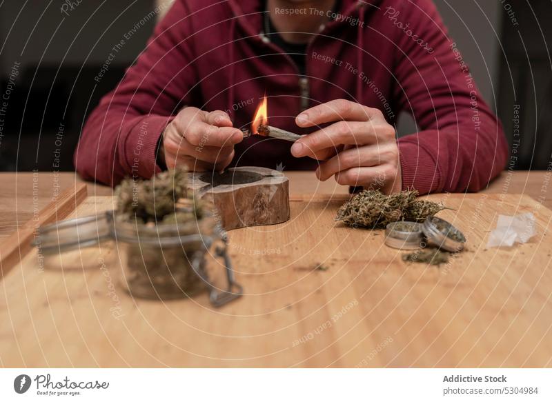 Crop-Mann zündet Blunt an, während er Cannabis raucht Rauch Raucherin Licht Gelenk stumpf Marihuana Flamme Brandwunde ganja männlich Erwachsener medizinisch