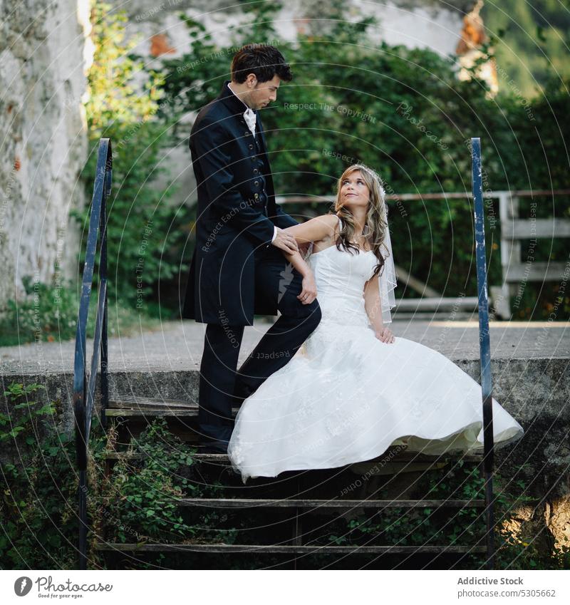 Ehepaar auf Treppe bei altem Gebäude Paar Hochzeit Freitreppe die sich gegenseitig ansehen Lächeln Braut striegeln Liebe umarmend romantisch elegant gealtert