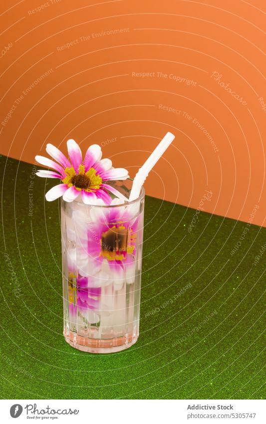 Glas mit frischem Cocktail, Blumen und Strohhalm Getränk trinken Erfrischung kalt Alkohol Blütezeit lecker farbenfroh Pflanze hell rosa durchsichtig