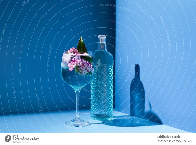 Cocktailglas in der Nähe der Kristallflasche Alkohol trinken Getränk Blume Glas Eis Schnaps Flasche kalt frisch Erfrischung liquide Tisch Aperitif hell feiern