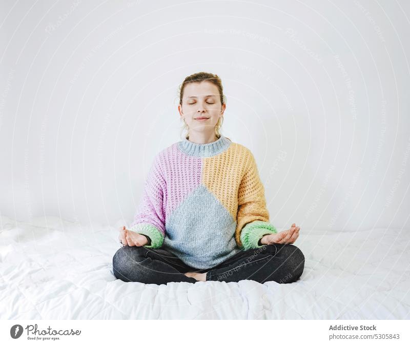 Ruhige Frau meditiert auf dem Bett meditieren Lotus-Pose Yoga Zen heimwärts üben Achtsamkeit Windstille Augen geschlossen sich[Akk] entspannen friedlich