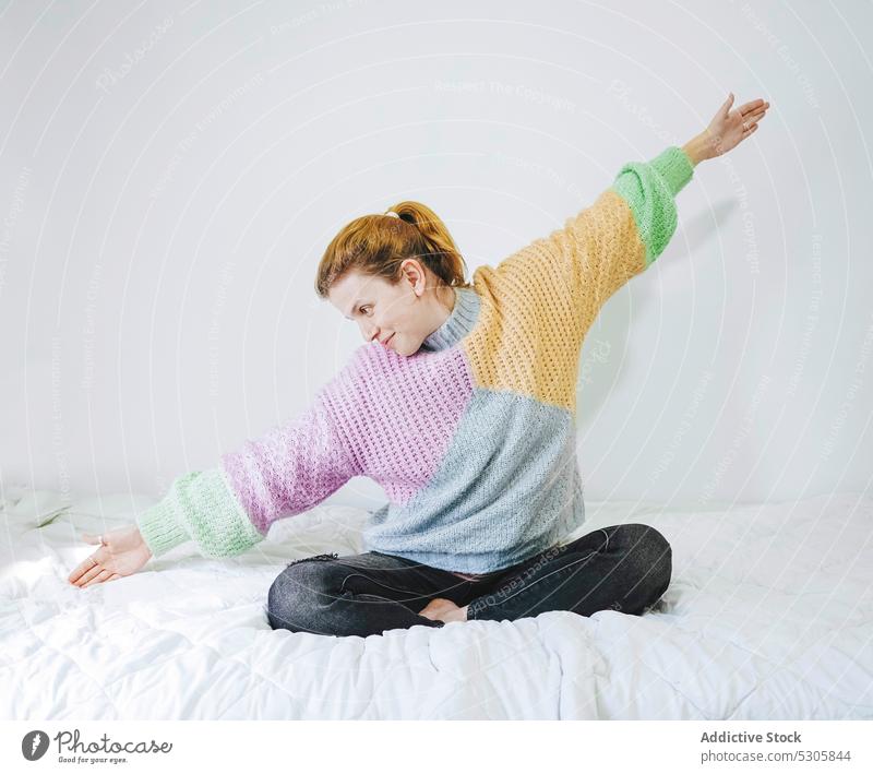 Zufriedene Frau streckt sich auf dem Bett Dehnung Lotus-Pose Morgen heimwärts Windstille sich[Akk] entspannen meditieren padmasana friedlich jung Komfort Yoga