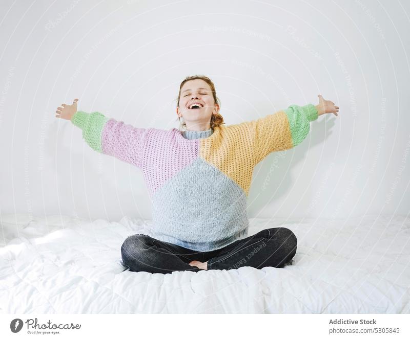 Lächelnde Frau meditiert auf dem Bett meditieren Lotus-Pose Yoga froh Zen heimwärts Freude üben Achtsamkeit Windstille Augen geschlossen sich[Akk] entspannen