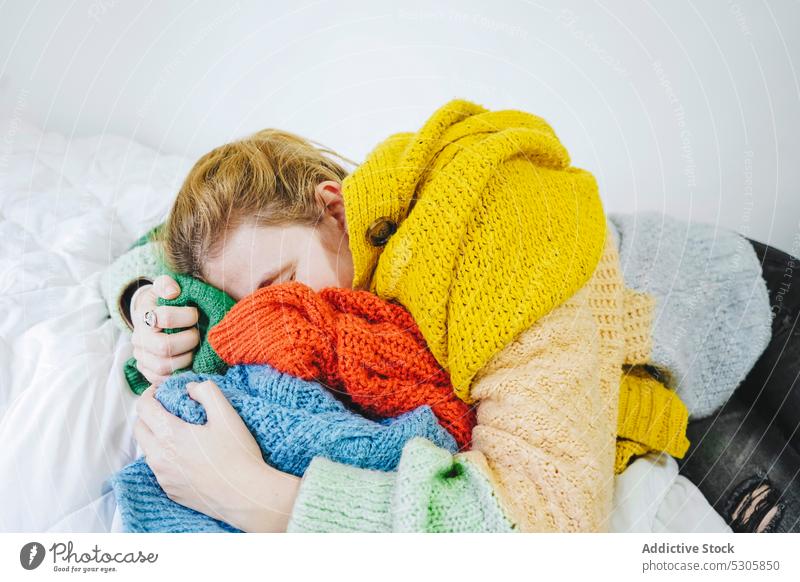 Entspannte Frau, die auf einem gestrickten Pullover auf dem Bett liegt Windstille Lügen Augen geschlossen Komfort sich[Akk] entspannen Stoff heimwärts