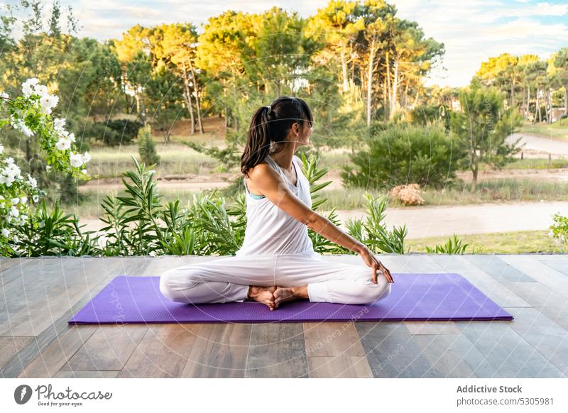 Gesichtslose Frau übt Meditation in der Natur Yoga sitzende Drehung üben Asana Park Wellness Parivritta Sukhasana Wald Sportkleidung pinamar Buenos Aires