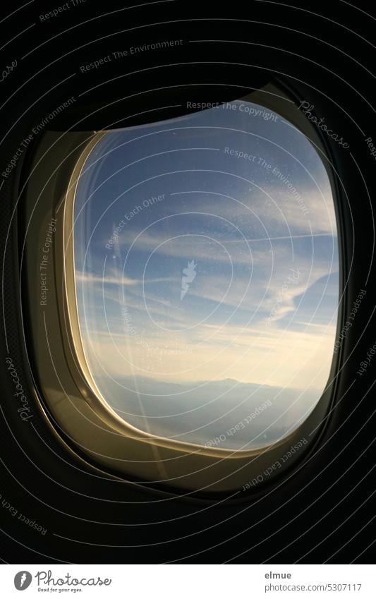 Blick aus einem fliegenden Flugzeug auf Chemtrails und Berge Flugzeugfenster über den Wolken Plexiglas Luftverkehr Urlaub Elba Fensterblende Passagierflugzeug