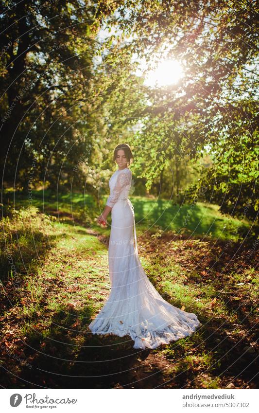 Braut im Brautkleid im Wald stehend Hochzeit Wälder Kleid Park Natur Frau im weißen Kleid langes weißes Kleid friedlich im Freien Porträt Sinnlichkeit