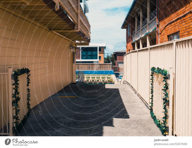 Gegenüberstellung | von senkrechten Flächen und Formen einer Einfahrt Abstellplatz Metallzaun Menschenleer Zaun Haus trist Stil Strukturen & Formen Schatten eng