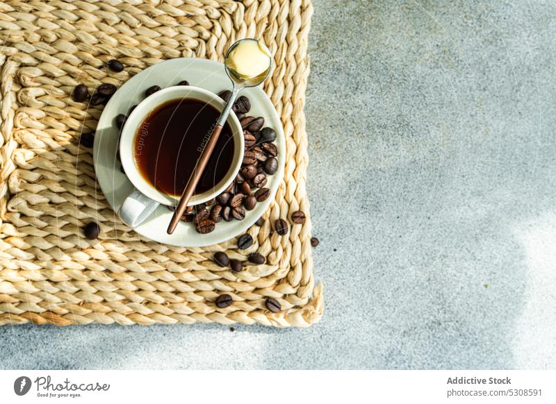 Kugelsicherer Kaffee mit Kaffeekörnern americano Hintergrund Bohne Getränk schwarz Frühstück kugelsicher Butter Keramik Beton Tasse trinken geblümt Blumen