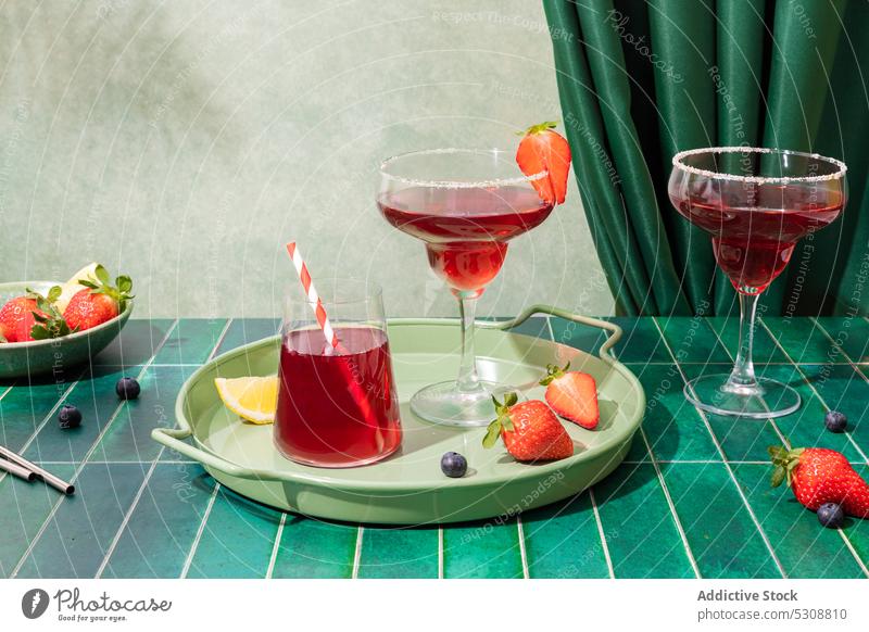 Erdbeer-Cocktails mit Beeren auf dem Tablett Alkohol Erdbeeren Glas trinken Erfrischung Zitrone dienen Bar Getränk Sommer lecker Scheibe Tisch Stroh kalt rot