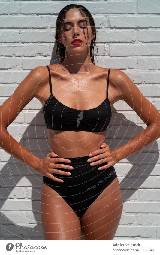 Schlanke Frau in Unterwäsche unter der Dusche im Freien sinnlich Urlaub Badebekleidung Sommer Bikini nass verführerisch Badeanzug schlank schwarz nasses Haar