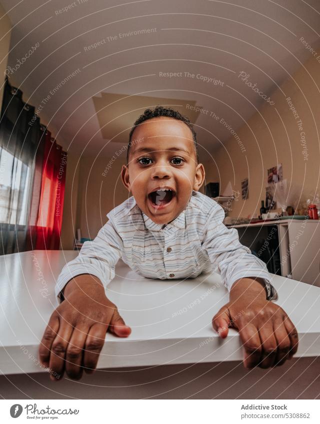 Bezaubernder glücklicher Junge schaut in die Kamera Kleinkind Glück niedlich bezaubernd Kind schwarz Afroamerikaner ethnisch zufrieden sich[Akk] entspannen