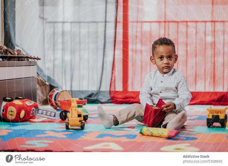 Niedlicher kleiner Junge spielt mit Spielzeug Kleinkind spielen sich[Akk] entspannen Teppich farbenfroh zu Hause niedlich bezaubernd Kind schwarz Afroamerikaner